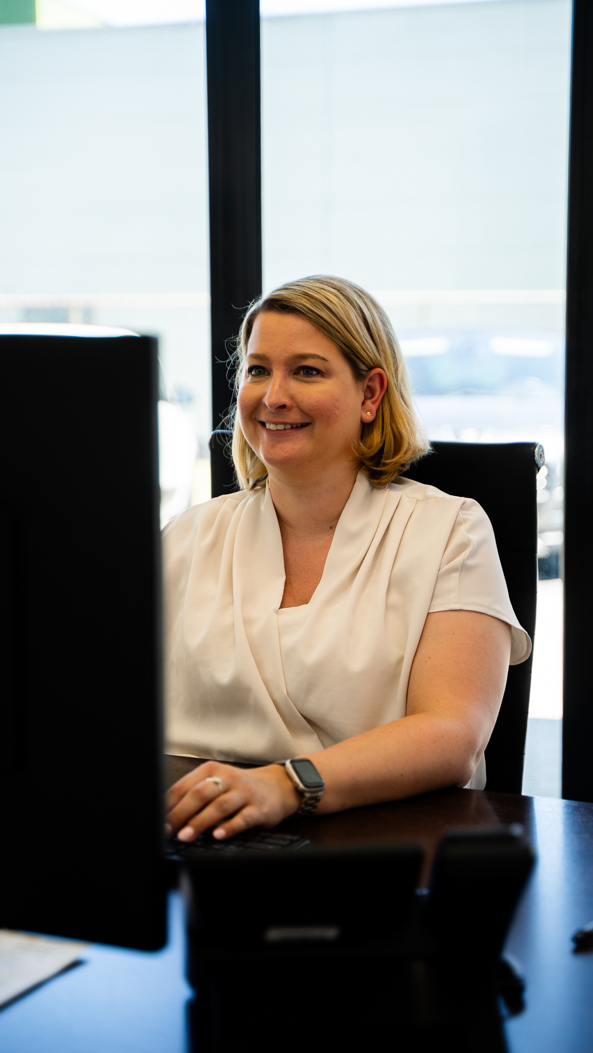 Steuerfachangestellte sitzt am PC und lacht.