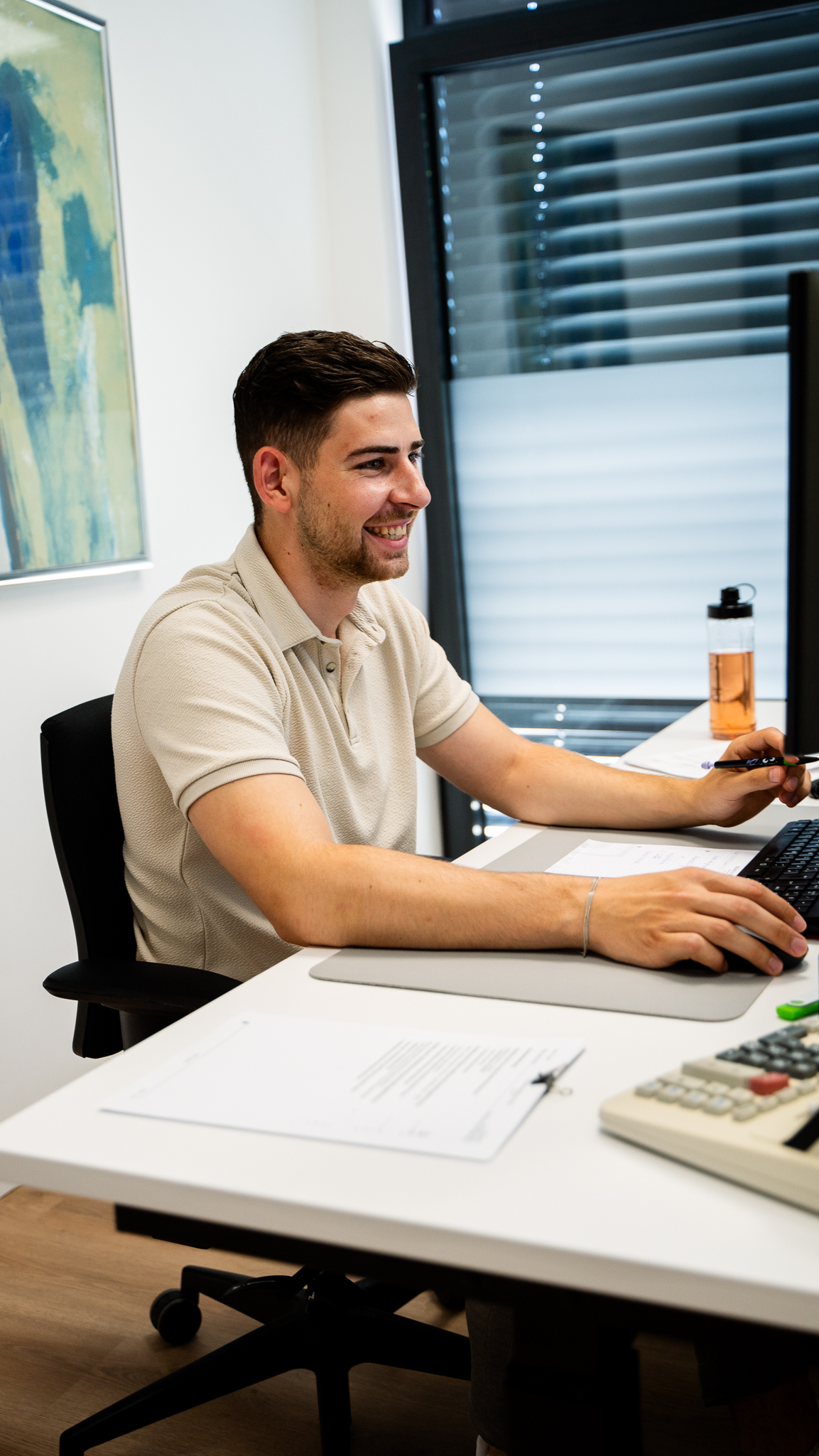 Steuerfachwirt sitzt am Schreibtisch und arbeitet mit dem PC.