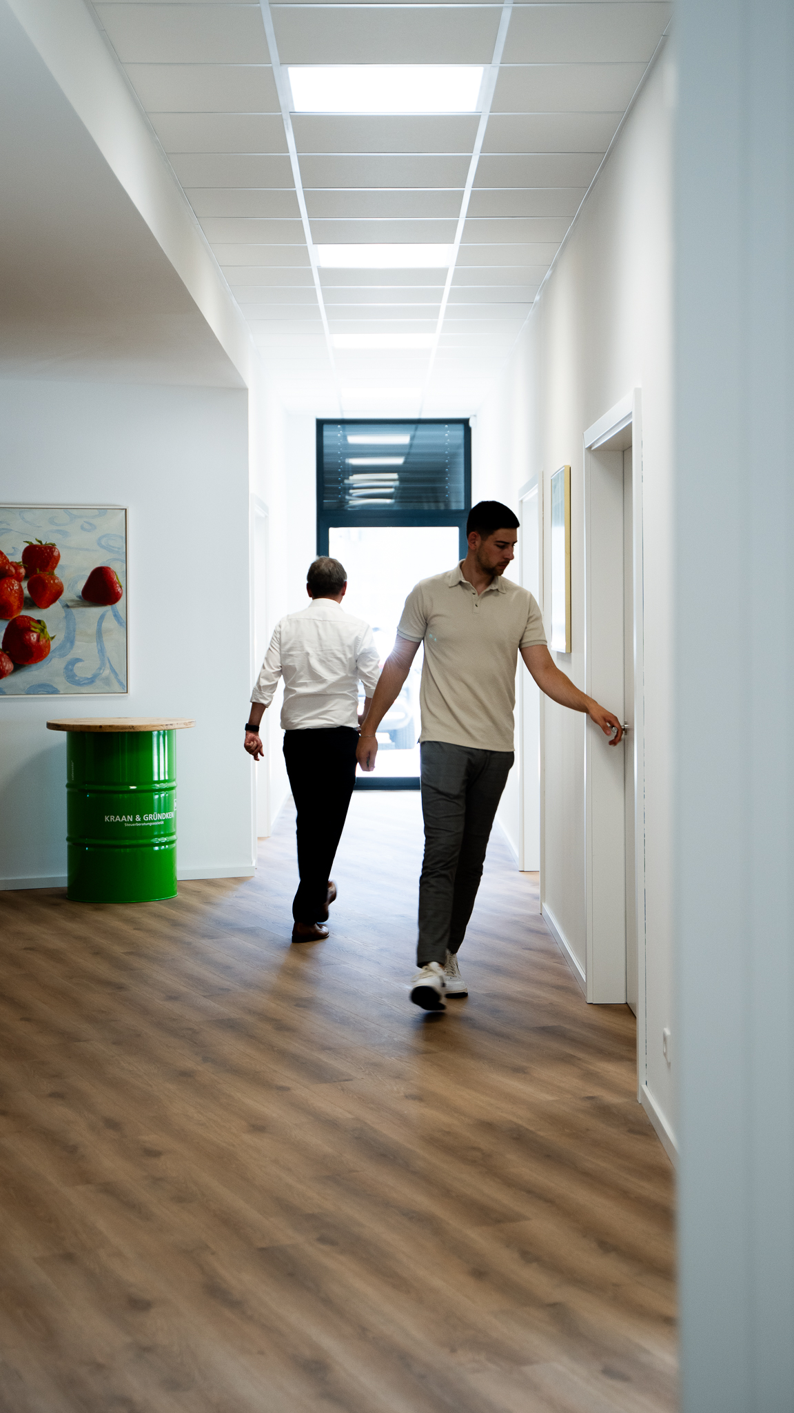 Zwei Mitarbeiter, die auf dem Flur entlang laufen.